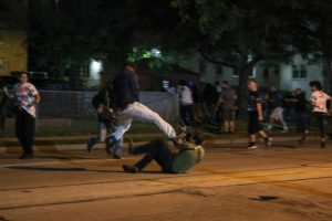 Kyle Rittenhouse, lying on his back as an unidentified man attempts to stomp on his head.  Meanwhile, Anthony Huber approaches Rittenhouse with his skateboard in hand. 

-
Image may be subject to copyright (Getty Images).